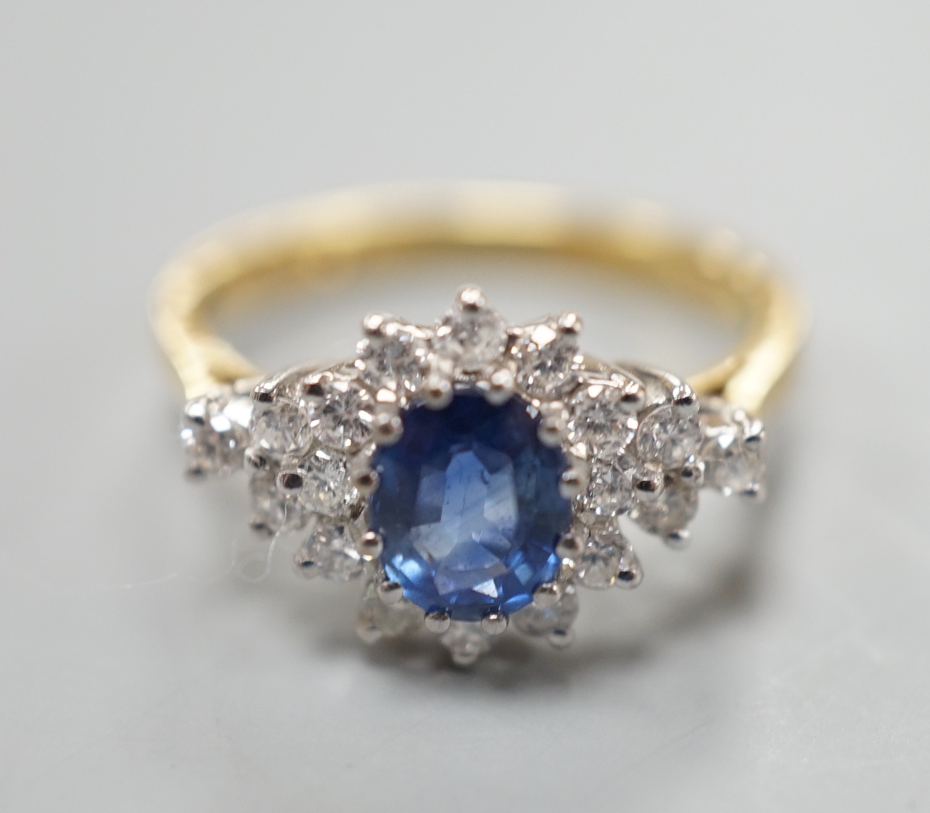 A modern 18ct gold, sapphire and diamond set elliptical shaped cluster dress ring, size N, gross weight 3.5 grams